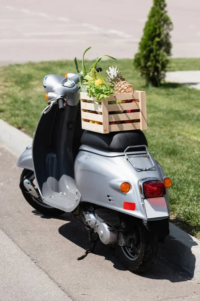 Boîte en bois avec des aliments frais sur scooter à l'extérieur — Photo de stock