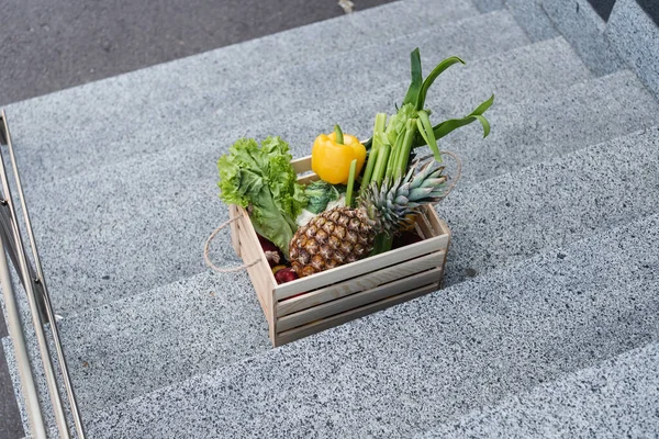 Vista de ángulo alto de verduras frescas y piña en escaleras al aire libre - foto de stock