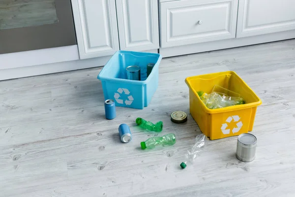 Boîtes avec panneau de recyclage près des ordures dans la cuisine — Photo de stock