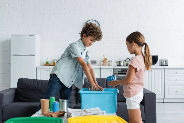 Діти сортують сміття біля кошика на кухні — стокове фото