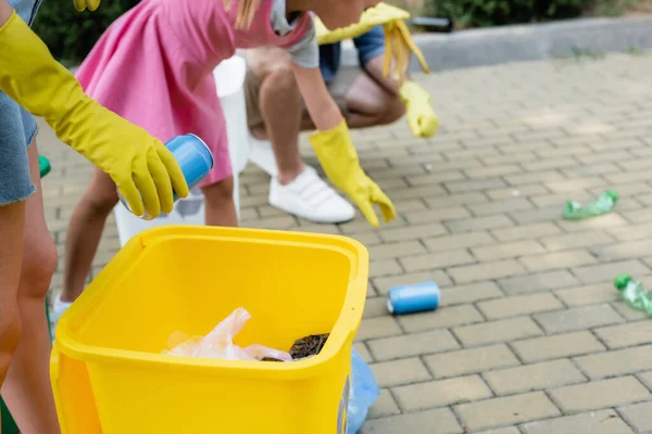 Woman holding tin can near trash bin outdoors — Stock Photo