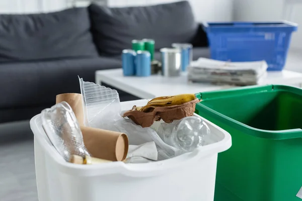 Basura de plástico y papel en lata en casa - foto de stock