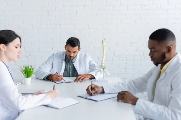 Médecins multiethniques travaillant avec des papiers dans la salle de réunion — Photo de stock