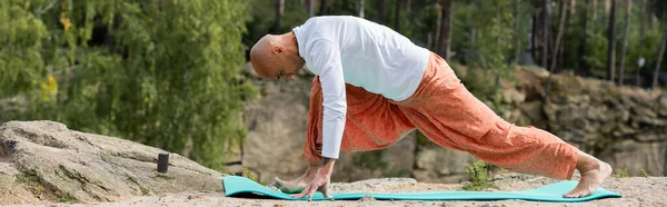 Side view of buddhist in white sweatshirt practicing yoga in crescent lunge pose, banner — Stock Photo