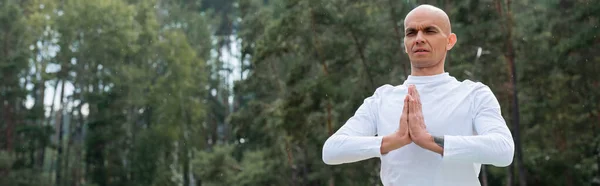 Budista em camisola branca meditando com as mãos orando na floresta, banner — Fotografia de Stock