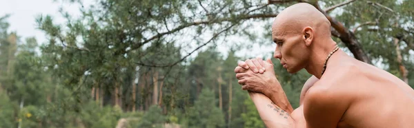 Shirtless buddhist meditating in yoga pose in forest, banner — Stock Photo