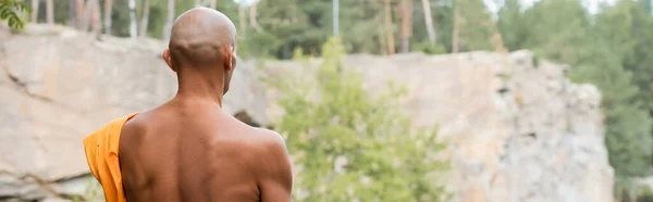 Back view of hairless buddhist meditating outdoors, banner — Stock Photo