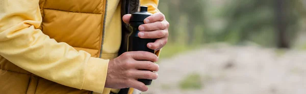 Cropped view of tourist opening thermo bottle outdoors, banner — Stock Photo