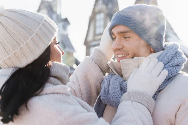 Jeune femme ajustement chapeau de petit ami heureux à l'extérieur — Photo de stock