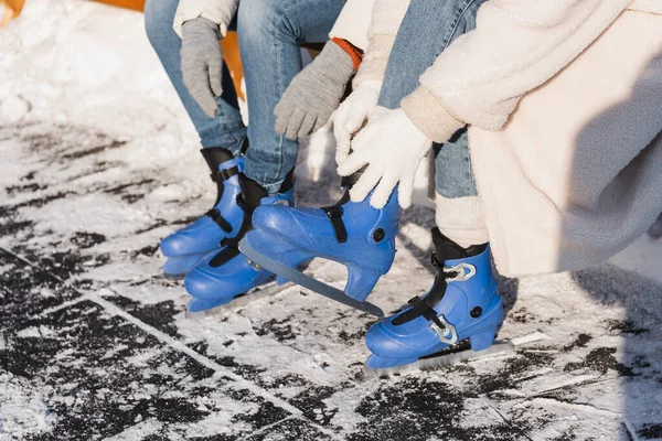 Cropped view of couple wearing ice skates — Stock Photo
