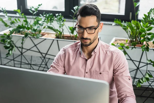 Uomo d'affari musulmano in occhiali da vista utilizzando il computer in ufficio — Foto stock