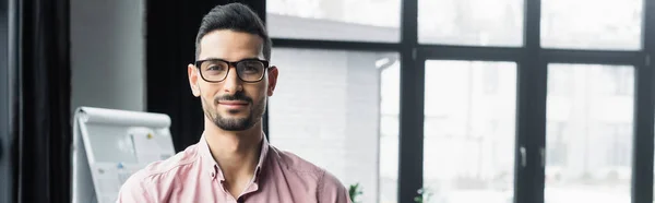 Uomo d'affari arabo con gli occhiali che guarda la macchina fotografica in ufficio, banner — Foto stock