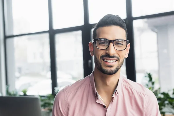 Happy arabian businessman in eyeglasses looking at camera in office — Stock Photo