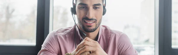 Homem de negócios muçulmano sorridente no fone de ouvido no escritório, banner — Fotografia de Stock