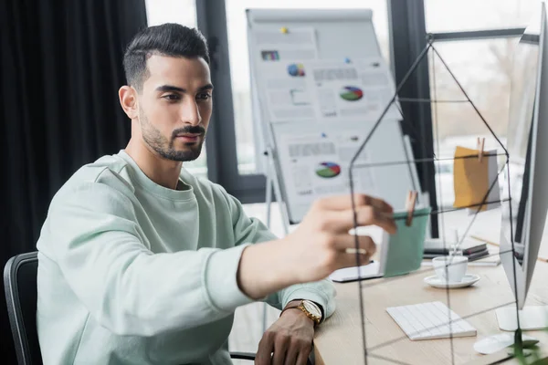 Arabian businessman looking at sticky notes near computer in office — Stock Photo