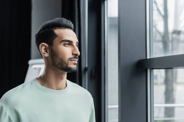 Young muslim businessman standing near window in office — Stock Photo