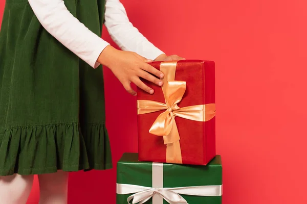 Cropped view of girl near gift boxes on red — Stock Photo