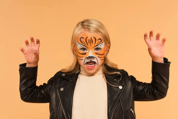 Chica enojada con cara de tigre pintura gruñendo y mostrando gesto de miedo aislado en beige - foto de stock