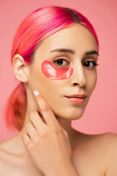 Jolie jeune femme aux cheveux colorés et bandeau hydratant isolé sur rose — Photo de stock