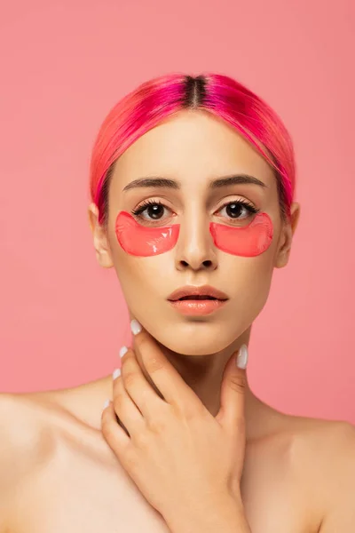 Mulher muito jovem com cabelos coloridos e manchas de olhos olhando para a câmera isolada em rosa — Fotografia de Stock