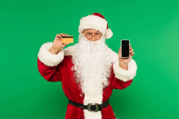 Papai Noel segurando cartão de crédito e smartphone isolado em verde — Fotografia de Stock