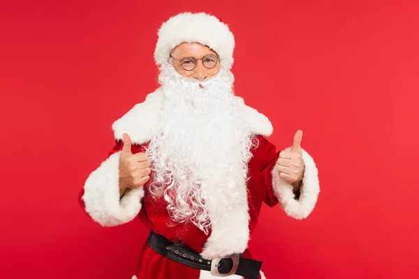 Père Noël en costume montrant comme geste isolé sur rouge — Photo de stock