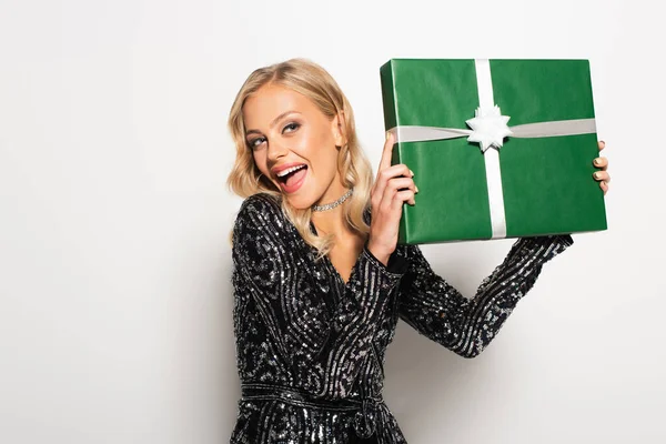 Overjoyed and elegant woman with present looking away on white — Stock Photo