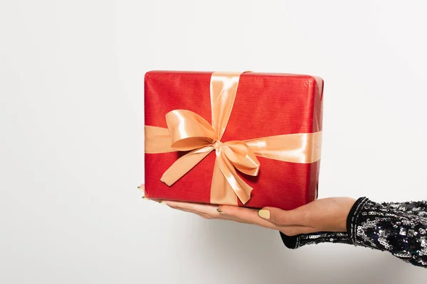 Vista ritagliata delle mani femminili con scatola regalo rossa su bianco — Foto stock