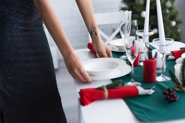 Vue partielle de la femme servant une table de fête avec des assiettes blanches — Photo de stock