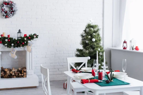 Moderno soggiorno con camino decorato, albero di Natale e tavolo servito per la cena festiva — Foto stock