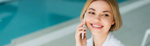 Mujer positiva hablando por teléfono móvil en el centro de spa, bandera — Stock Photo