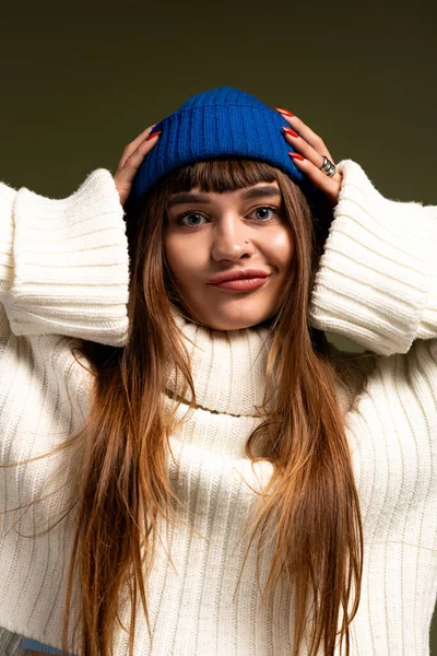 Caldamente vestita giovane donna posa giocosamente, abbracciando la bellezza della moda autunno e inverno. — Foto stock