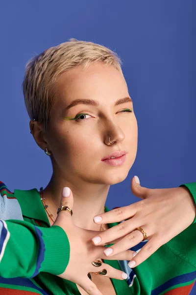Una mujer joven y hermosa muestra su sentido de la moda con estilo lúdico contra un fondo brillante. - foto de stock