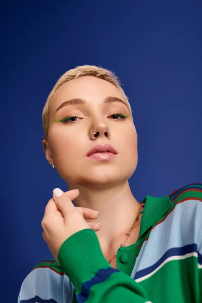 Mujer joven con estilo muestra su traje de moda y maquillaje, exudando confianza y estilo. - foto de stock