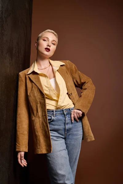 Mujer de moda muestra su traje elegante con una expresión audaz en un espacio creativo. - foto de stock