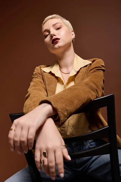 Chic young woman with short hair exudes poise while seated in her modern style. — Stock Photo