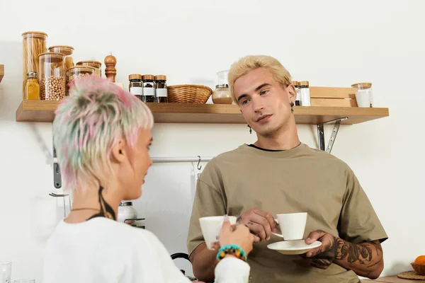 Молодая пара наслаждается теплым моментом, потягивая кофе в очаровательной атмосфере кафе. — стоковое фото