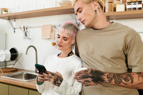 Paar genießt die Gesellschaft des anderen und teilt das Lachen beim Telefonieren in der Küche. — Stockfoto