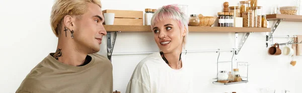 Радісна пара обмінюється люблячими поглядами на стильну кухню, оточену красивим декором. — стокове фото