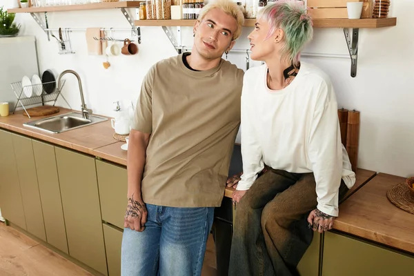 Молодая пара смеется на теплой, стильной кухне. — стоковое фото