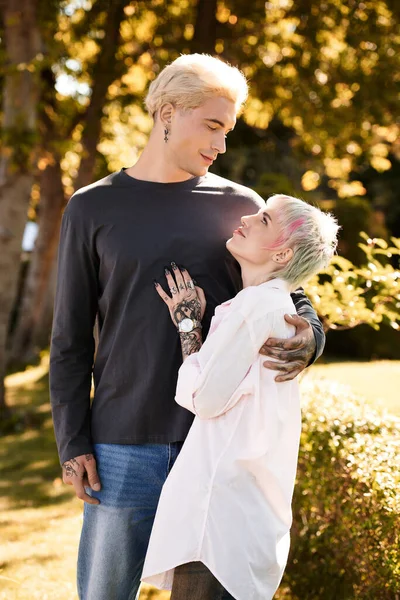 Молодая пара нежно обнимается, окруженная природой красоты в спокойной обстановке сада. — стоковое фото