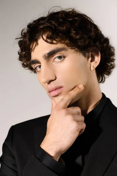 Молодой красивый мужчина задумчиво позирует, одетый в шикарный костюм, эксгумируя без особых усилий. — стоковое фото