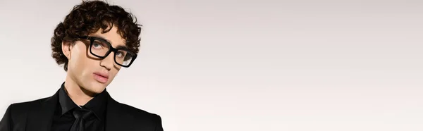 Jovem encantador mostra sentido de moda único com óculos elegantes em um ambiente contemporâneo. — Fotografia de Stock