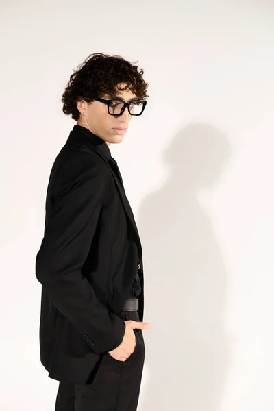 Homem de traje preto chique fica confiante, destacando o estilo contemporâneo e elegância. — Fotografia de Stock