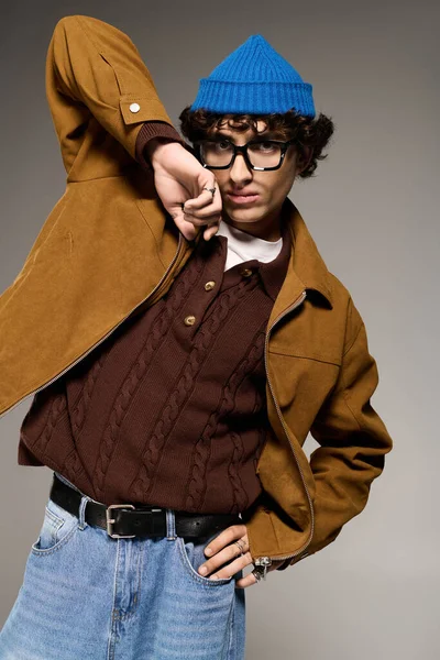 Молодий чоловік у стильному вбранні впевнено позує, поєднуючи сучасні тенденції з особистим чуттям. — стокове фото