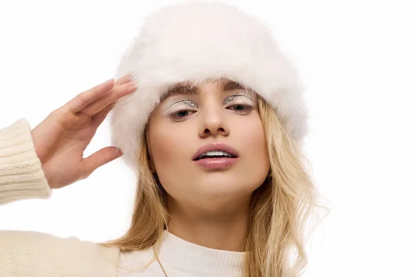 Молодая блондинка моделирует уютную зимнюю моду на белом фоне. — стоковое фото