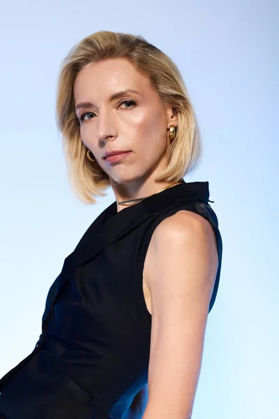 Confidence radiates from a blonde woman in a chic black vest, full of elegance and style. — Stock Photo