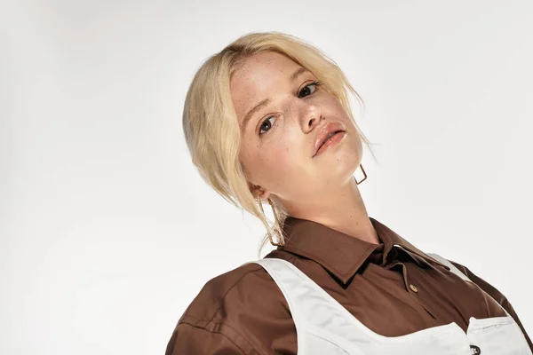 Молодая блондинка уверенно позирует в модном зимнем наряде на белом фоне. — стоковое фото