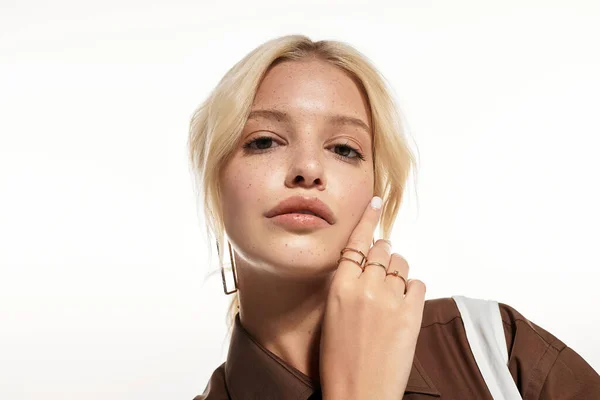 Красива молода блондинка позує елегантно в стильному зимовому вбранні в білій студії. — стокове фото