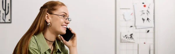 Молода жінка насолоджується затишною атмосферою під час розмови по телефону вдома, випромінюючи щастя. — стокове фото